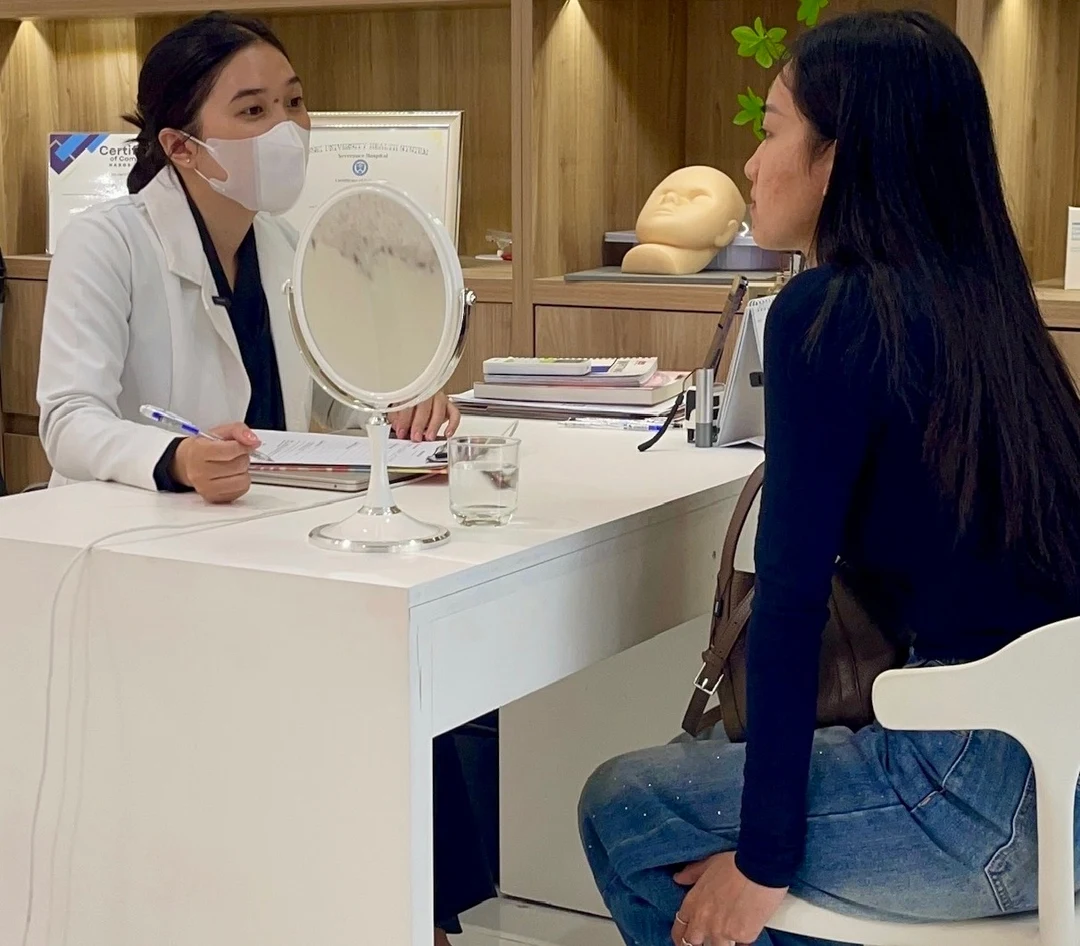 A consultation at Eternal Beauty Center: talking through skin concerns at the consultation desk, with a mirror to look at the skin together