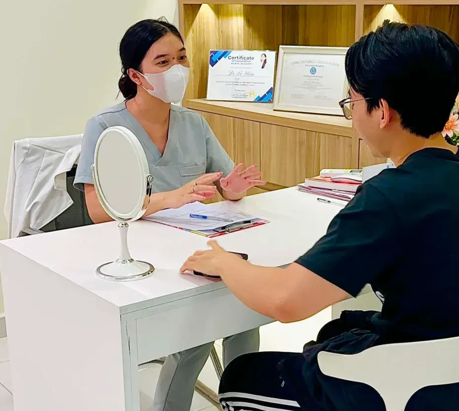 A dermatologist talking with a client across a consultation desk with a mirror at Eternal Beauty Center: scars are classified before a method is chosen