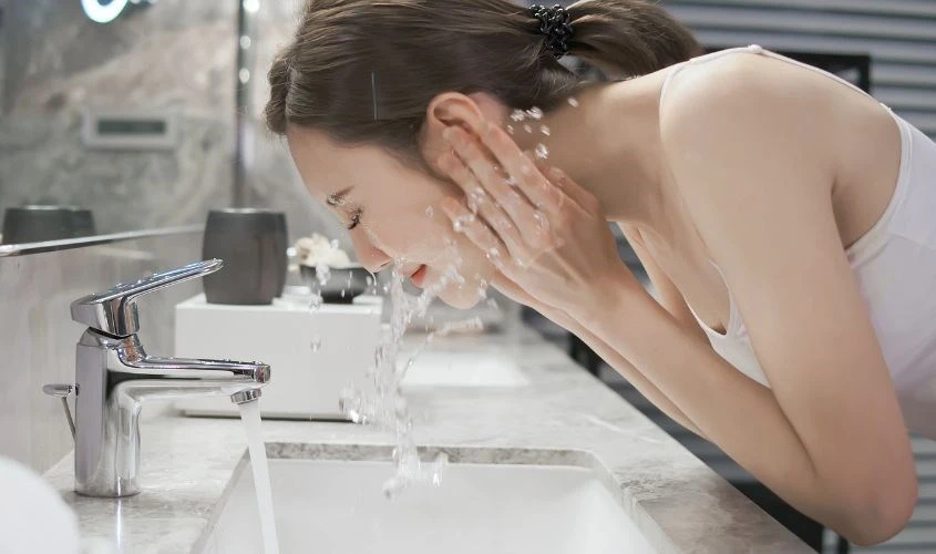 Washing the face with lukewarm water and fingertips — the evening cleanse is almost always needed after a day of sweat, sebum, sunscreen and dust